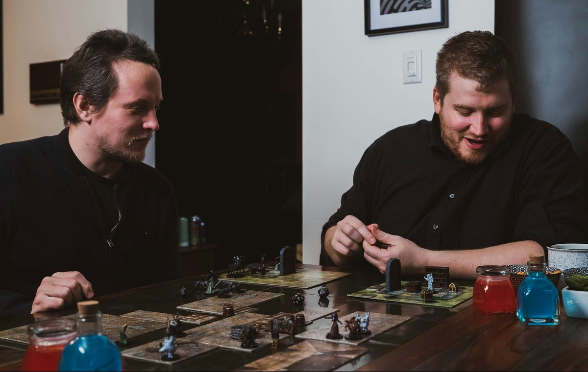 Two players testing a tabletop game with prototype pieces